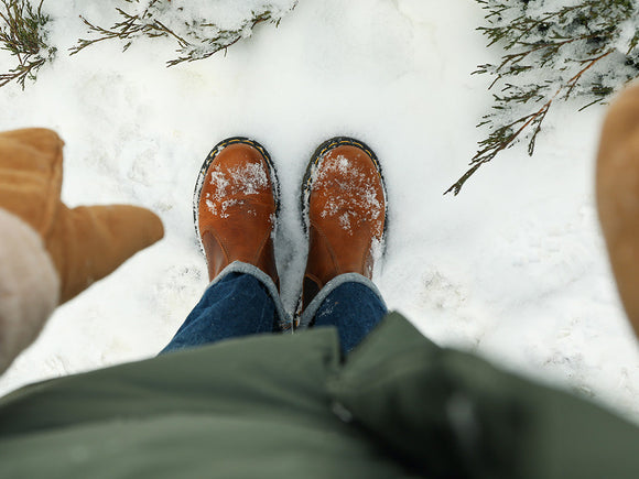Große Frau mit Jeans steht im kalten Schnee